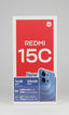 Redmi 15C smartphone retail packaging card held in a hand, showing a pink front panel with large white 'REDMI 15C' text, a blue phone illustration, and feature callouts including 16GB RAM, 256GB ROM, 6000mAh battery, and 6.9" display.