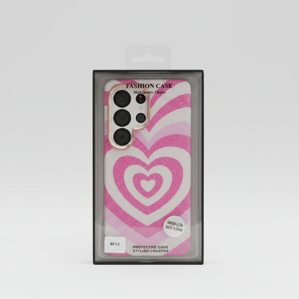 A pink and white heart-patterned protective phone case in its black retail packaging, displayed on a white table inside a store. Main image
