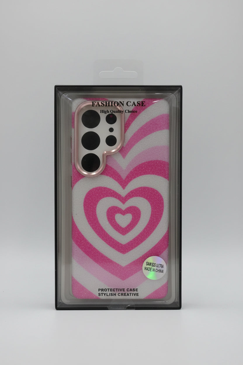 A pink and white heart-patterned phone case in its original retail packaging, featuring a glittery finish and a clear camera cutout. Main image