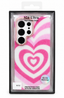A pink and white heart-patterned protective phone case in its retail packaging, featuring a spiral heart design and a camera cutout.