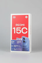 A blue Xiaomi Redmi 15C smartphone shown next to its red and white retail packaging box on a wooden surface.