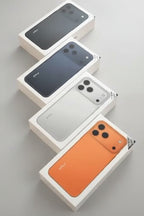 Four boxed smartphones arranged diagonally on a peach background, showing the front and back of each phone in black, dark gray, silver, and orange. The text 'ATFLY' and '17 Pro Max' appears at the top.