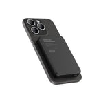 Black power bank attached to a smartphone on a white background