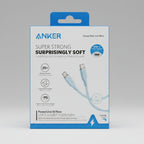 Anker Super Strong Surprisingly Soft USB-C to USB-C 100W power line flow cable in its retail packaging, displayed outdoors on a rock with a canyon and blue sky background.