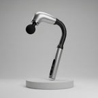 A handheld curved massage device with a metallic silver body and black neck, shown standing on a red circular base against a red gradient background. White marketing text on the left lists features such as deep tissue massage, multiple speeds, long-lasting battery, and portability.