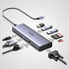 A silver and black 3-in-1 USB-C hub by UGREEN, shown with various connected and attached accessories including a USB-C cable, HDMI cable, USB flash drives, SD cards, and a VGA adapter on a white background.