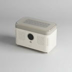 A portable car air freshener diffuser with a clear lid and multiple LED light bulbs on top, placed on a car center console next to a light blue leather seat. The brand name 'BONJOOO' is visible on the front.